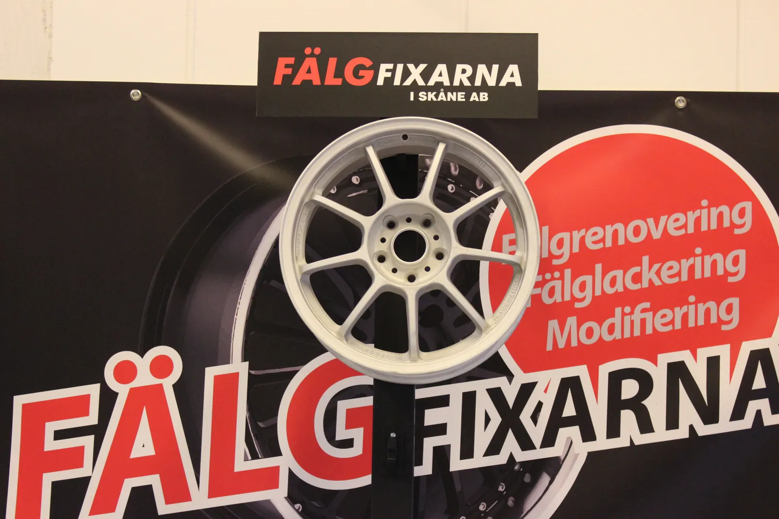 Fälgfixarnas skylt i verkstaden i Helsingborg med logotypen och en renoverad fälg